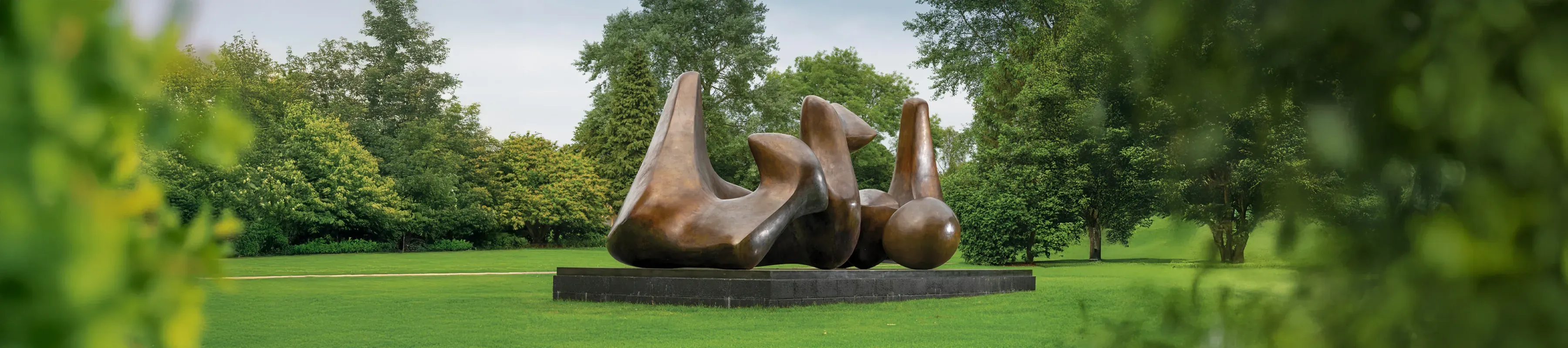 A Henry Moore sculpture surrounded by trees 