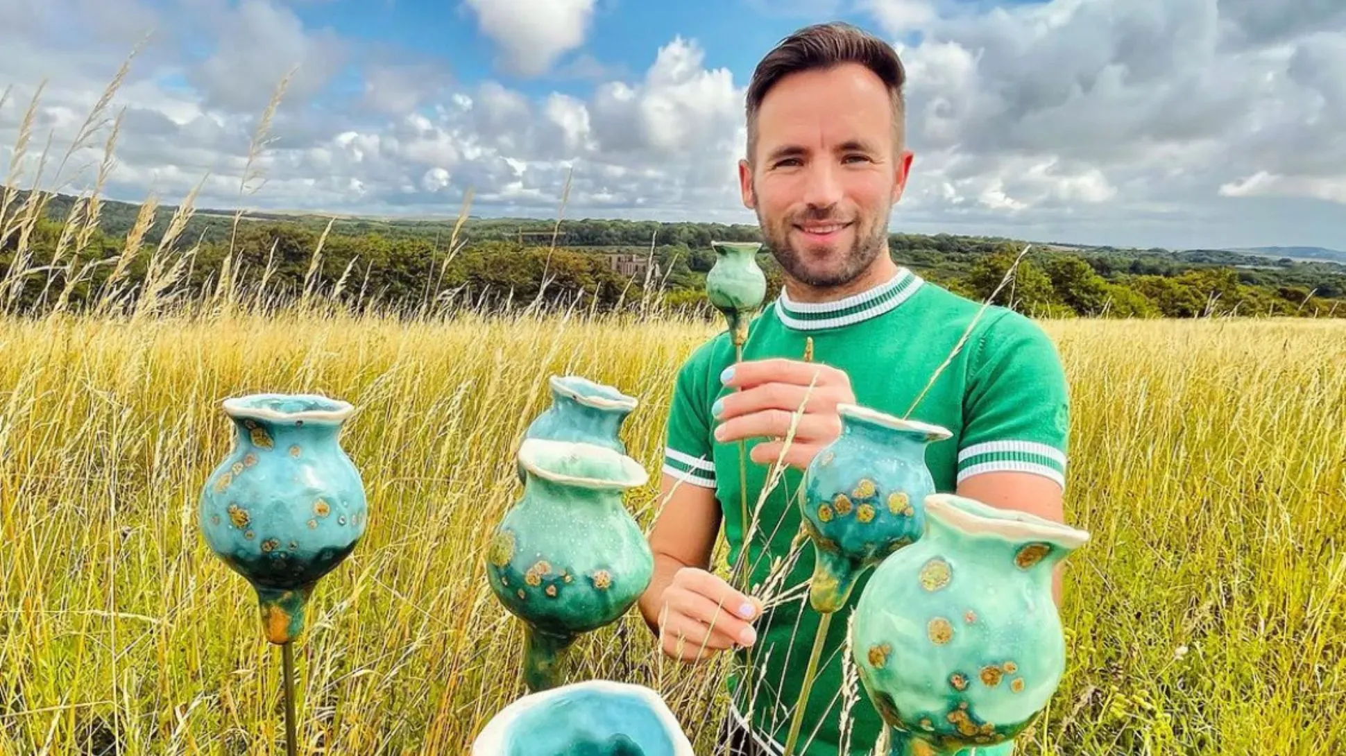 Ceramic artist Adam Ceramic in a meadow, with ceramic sculptures in front