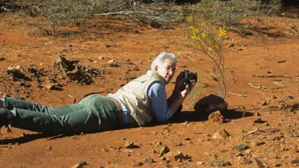 Kew Scientist Gwil Lewis takes photos while laying on the ground