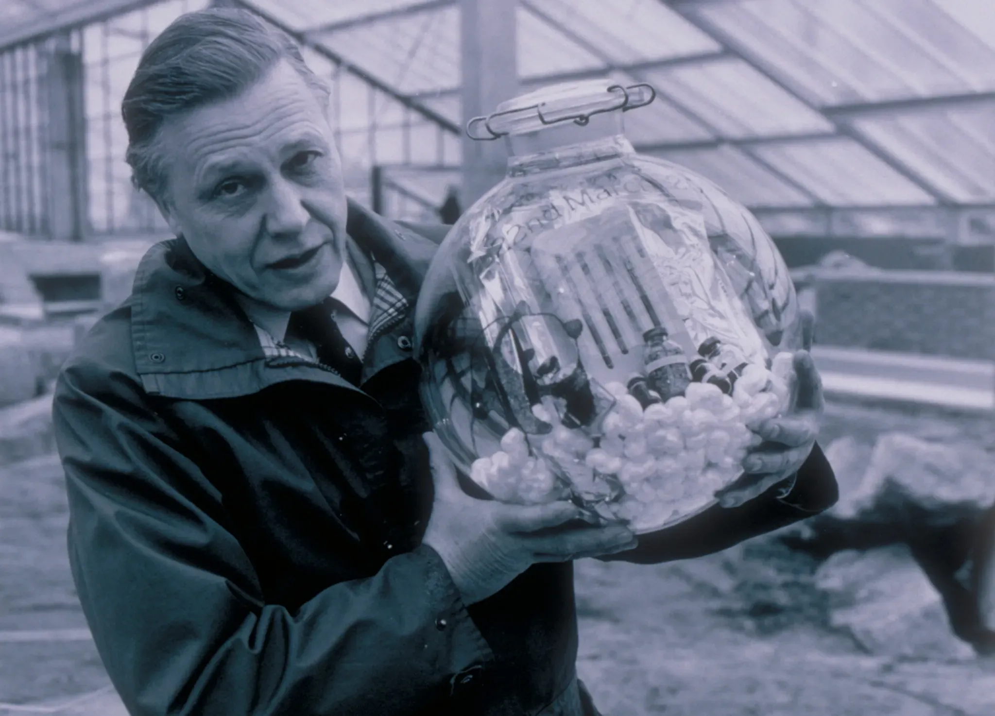 David Attenborough holding a time capsule before it was buried in the foundations of the Princess of Wales Conservatory 