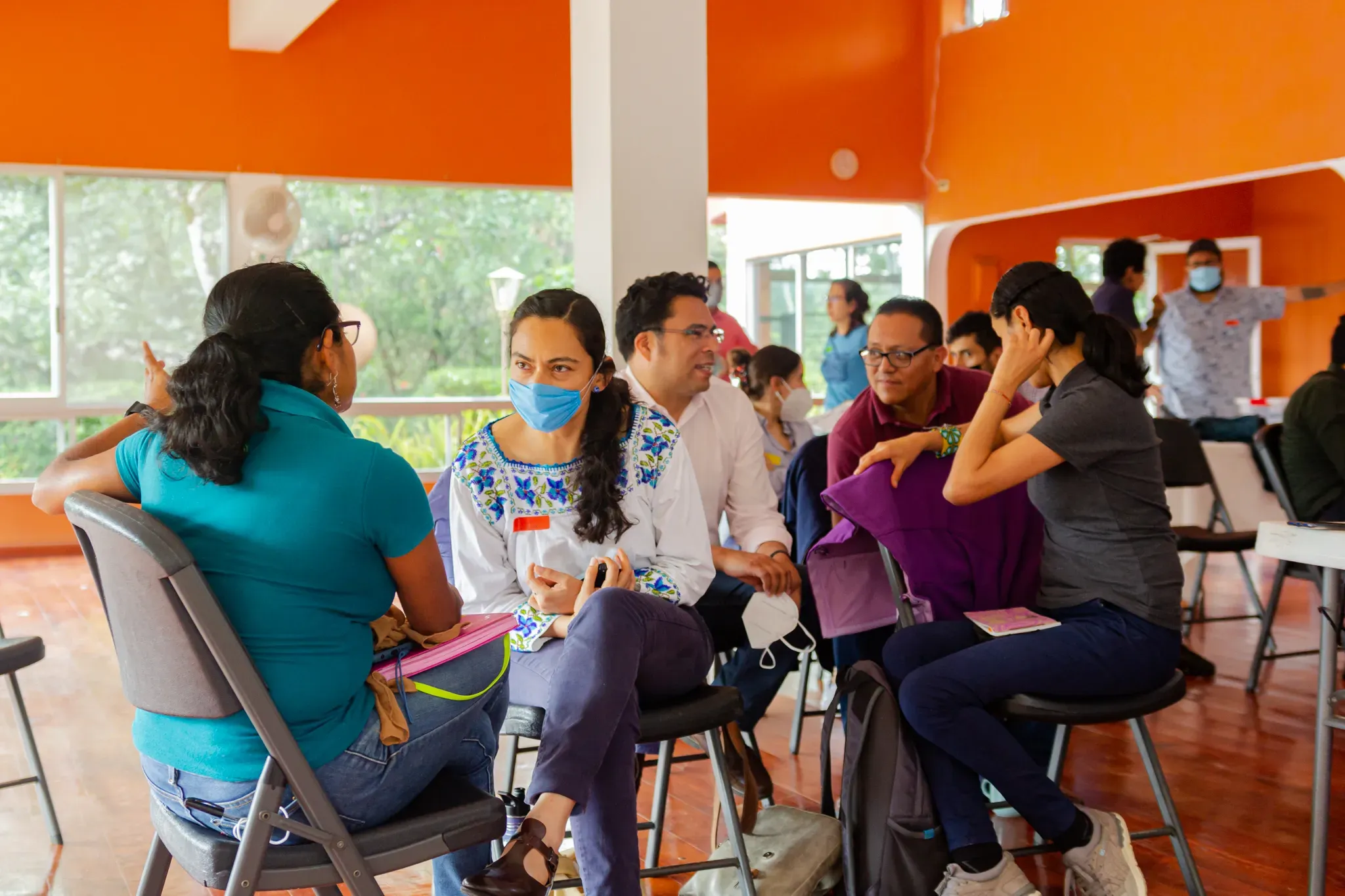 A group of training participants share discussions in a large open room