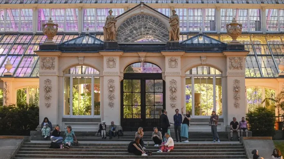 People sitting in front of the Temperate House in the evening