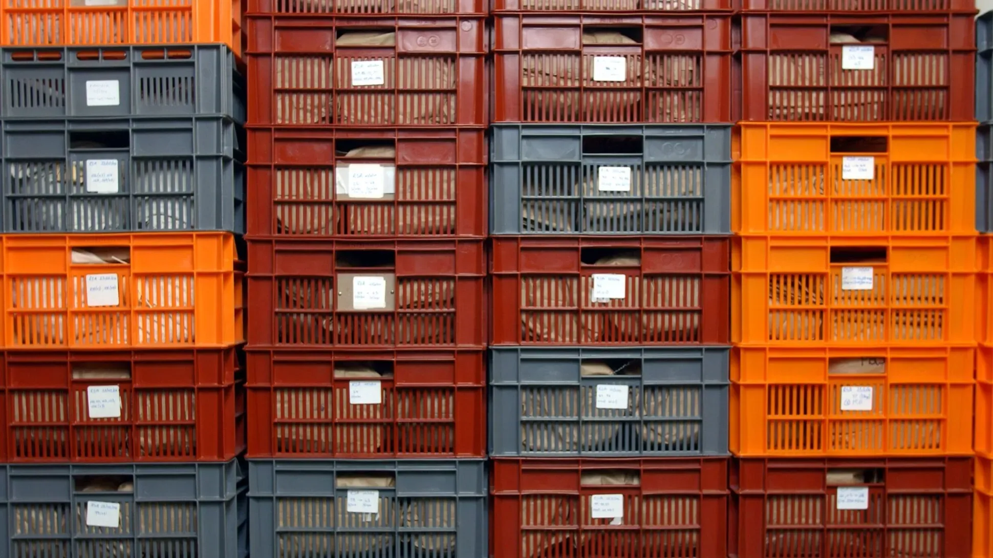 Many orange and red plastic crates stacked on top of each other